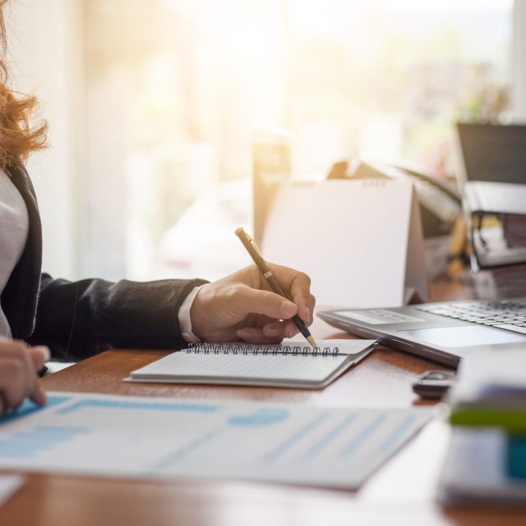 Business woman at working with financial reports and laptop computer in the office