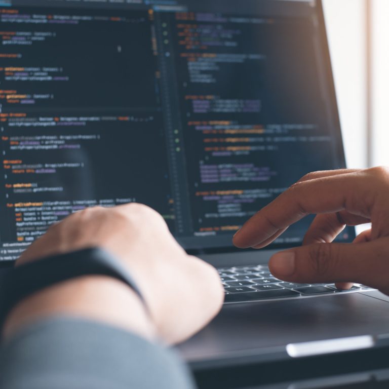 Web or application design, business and technology concept. Programmer typing HTML code, Javascript on laptop computer, at workplace close up